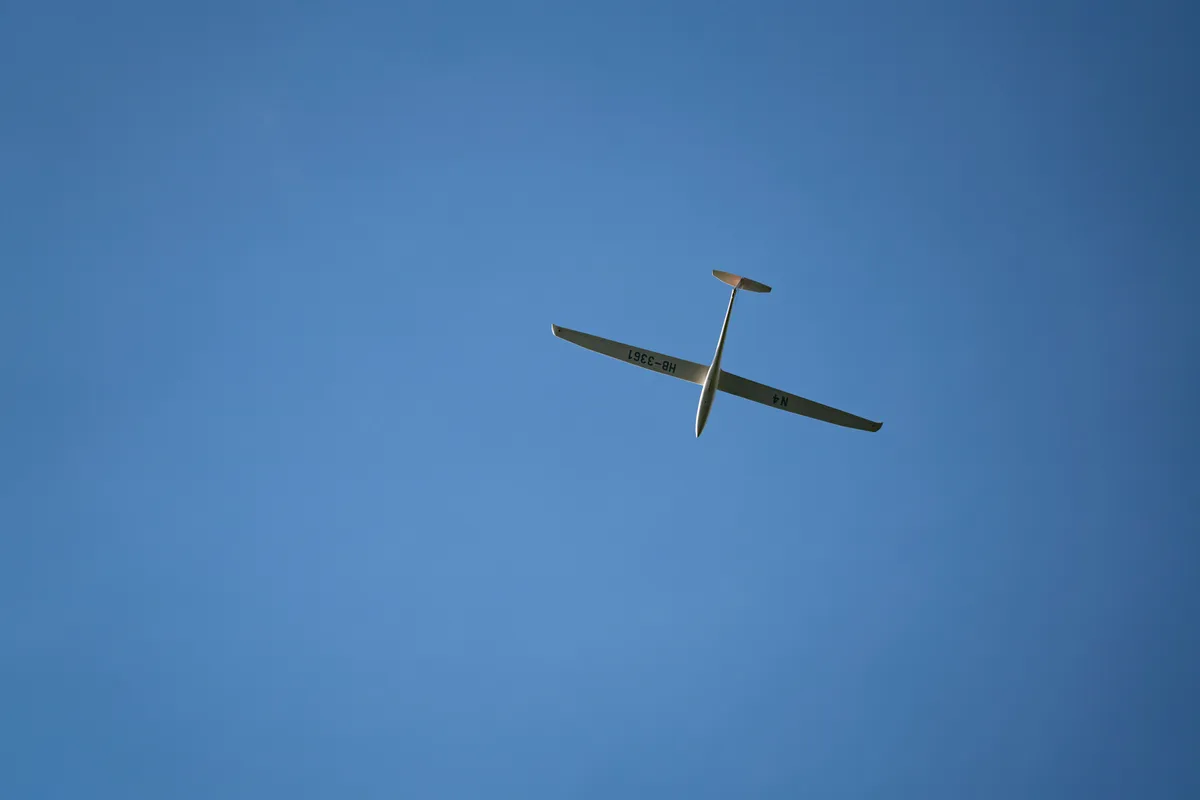 Un planeur en vol dans un ciel bleu dégagé, porté sans moteur